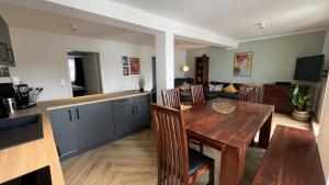 a kitchen and dining room with a wooden table at discovAIR - Super Zentral mit Parkplatz, 3 Schlafzimmer & Netflix & mehr in Eisenach +27 photos