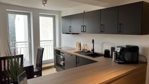 a kitchen with black cabinets and a counter top at discovAIR - Super Zentral mit Parkplatz, 3 Schlafzimmer & Netflix & mehr in Eisenach