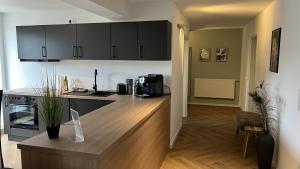 a kitchen with black cabinets and a wooden counter top at discovAIR - Super Zentral mit Parkplatz, 3 Schlafzimmer & Netflix & mehr in Eisenach