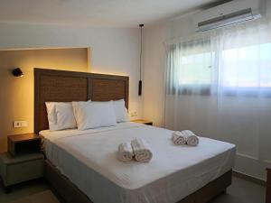 a bedroom with a bed with two towels on it at Sagini Suites in Paradisos +65 photos