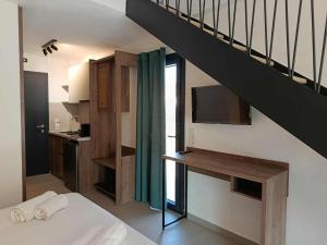 a room with a bed and a staircase with a television at Sagini Suites in Paradisos