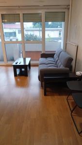 Appart cosy proche de Paris في فيلوجويف: غرفة معيشة مع أريكة وطاولة قهوة