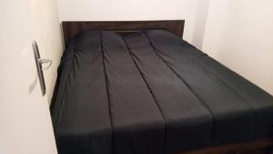 Appart cosy proche de Paris في فيلوجويف: سرير مع لحاف أسود في غرفة