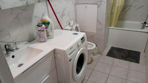 Appart cosy proche de Paris في فيلوجويف: حمام مع غسالة ومغسلة