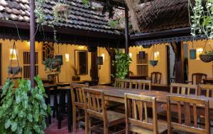 a dining room with a wooden table and chairs at Vrindavanam Heritage Home in Alleppey