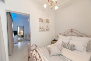 a bedroom with a white bed with white pillows at 12 Olympian Gods in Platamonas