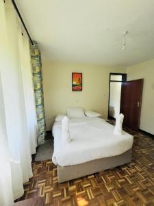a bedroom with two beds with white sheets at hostPoa in Eldoret