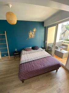 Un dormitorio con una cama y una pared azul. en Appartement St Cast centre ville 50 m de la plage, en Saint-Cast-le-Guildo