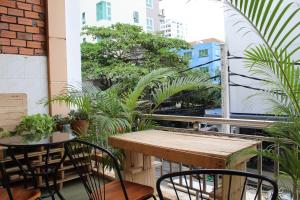 a table and chairs on a balcony with plants at KN HOSTEL & Coffee - Spa in Phnom Penh