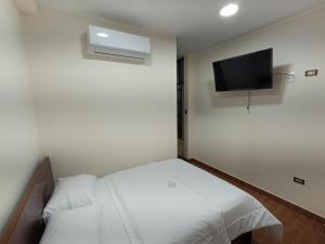 a small room with a bed and a flat screen tv at Morro Calzada in Moyobamba