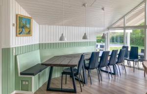 a dining room with a wooden table and chairs at Holiday Home Vibelunden Rødby X in Kramnitse