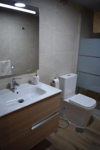 Un baño con lavabo, inodoro y espejo. en Marruecos, 19, en Córdoba