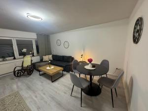 a living room with a couch and a table and chairs at Lajlas'Suite in Vellmar in Vellmar