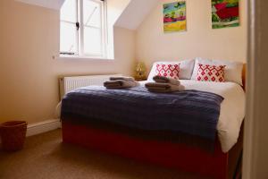 a bedroom with a bed with two towels on it at Templar Mews, town centre 2 bedroom, 2 bathroom house in Cirencester