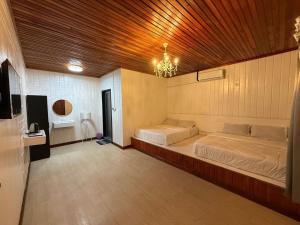 a bedroom with two beds and a wooden ceiling at Dezara Village in Semporna