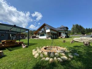 a yard with a fire pit in front of a house at Vila Eruga- Apartament 5 in Poiana Mărului