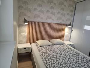 a small bedroom with a bed and two night stands at Tauzen Apartaments 31 in Katowice