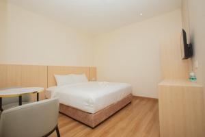 a bedroom with a bed and a table and a tv at HOTEL 101 Permas Jaya NEW in Johor Bahru +61 photos