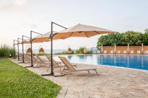 a row of chairs and an umbrella next to a pool at Arapya Sun Resort in Arapya