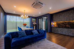 a living room with a blue couch and a table at Modern House Uprompt Chiangmai in Chiang Mai