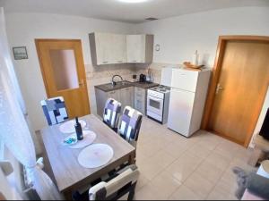 a kitchen with a table and chairs and a refrigerator at Let in Brod Moravice