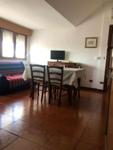 a living room with a table and chairs and a bed at Milou Home vicino Ospedale S Francesco in Nuoro