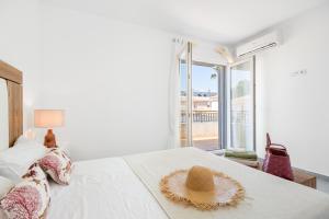 a white bedroom with a straw hat on a bed at Casa Estaca in Orihuela Costa +23 photos