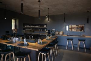 a bar with a long wooden table and stools at Ecodomaine & Distillerie U Viaghju in Muro