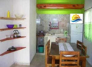 eine Küche mit Esstisch und grüner Wand in der Unterkunft Cabañas rio hondo in Termas de Río Hondo