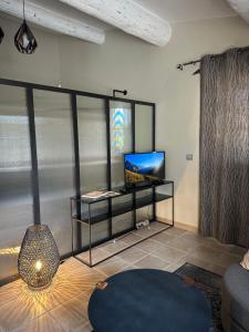 a living room with a tv and a couch at Gite Monet in Bouchet +23 photos