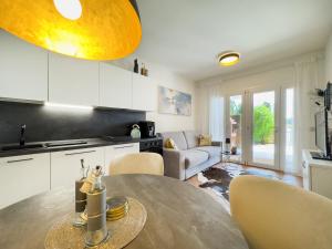 a kitchen and living room with a table and chairs at Ca' dei Vigneti in Colà di Lazise