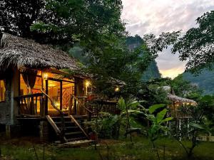 a house with a thatched roof with a staircase outside at Thái Tâm homestay in Mai Chau