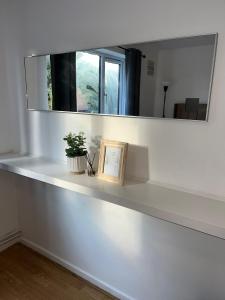 a white shelf with a mirror and a picture at Stylish 1 Bed Apartment - Birmingham city Centre in Birmingham