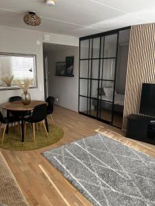 a living room with a table and chairs and a television at Great two bedrooms apartment with a sea view from the balcony close Helsinki center in Helsinki