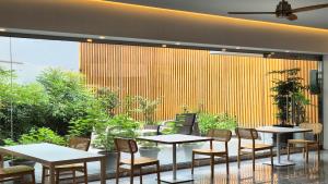 Um restaurante com mesas e cadeiras e uma grande janela. em Shire Heritage hotel em Busan