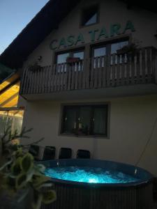 a building with a swimming pool in front of it at Casa de vacanța Tara in Rau Sadului