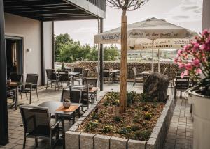 a restaurant with tables and chairs and an umbrella at Landhaus Kaiser in Abenberg