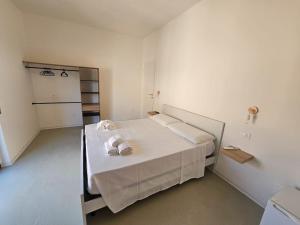 a white room with a bed with towels on it at Smart rooms in Santa Maria del Cedro
