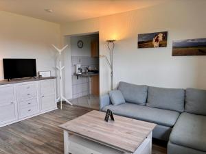 a living room with a blue couch and a tv at Ferienhof Schiefen - Urlaub auf dem Bauernhof in Eitorf