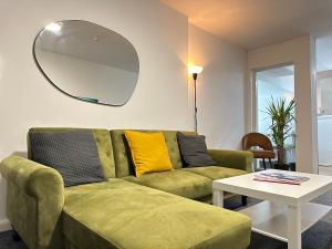 a living room with a green couch and a table at The Bath Street Retreat in Ilkeston