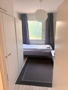 Cozy 2 Bedroom Apartment Near Santa Claus Village with space for 5 في روفانييمي: غرفة نوم صغيرة بها سرير ونافذة