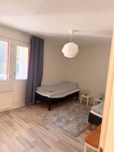 Cozy 2 Bedroom Apartment Near Santa Claus Village with space for 5 في روفانييمي: غرفة نوم بسرير ونافذة وثريا