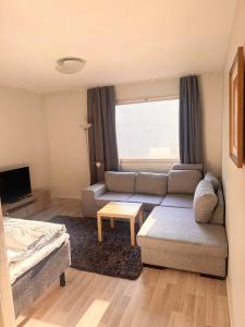 Cozy 2 Bedroom Apartment Near Santa Claus Village with space for 5 في روفانييمي: غرفة معيشة صغيرة مع أريكة وطاولة