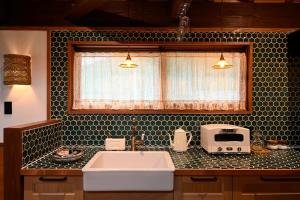 a kitchen counter with a sink and a window at Koya Miyama in Nantan city