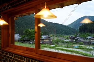 a window with a view of a village and mountains at Koya Miyama in Nantan city +13 photos