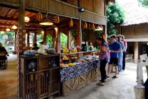 a group of people standing in front of a food stand at Thái Tâm homestay in Mai Chau