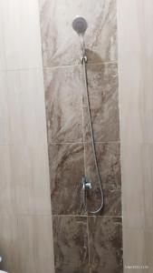 a shower with a shower head in a bathroom at Varisha Homestay 2 Bedrooms, PS5, E-bike in Ngaglik
