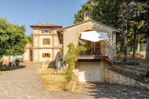 a building with a gate and a building with an umbrella at Oasi in the garden Cozy home - Perugia in Perugia