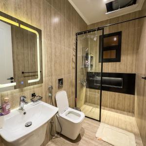a bathroom with a toilet and a sink and a shower at Luxury Smart Apartment B12 in Riyadh +42 photos
