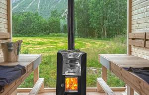 a wood stove in a room with a window at Cozy Home In Elvegard With Sauna in Elvegård